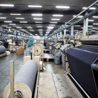 Weaving fabric on air jet looms in big textile weaving unit.